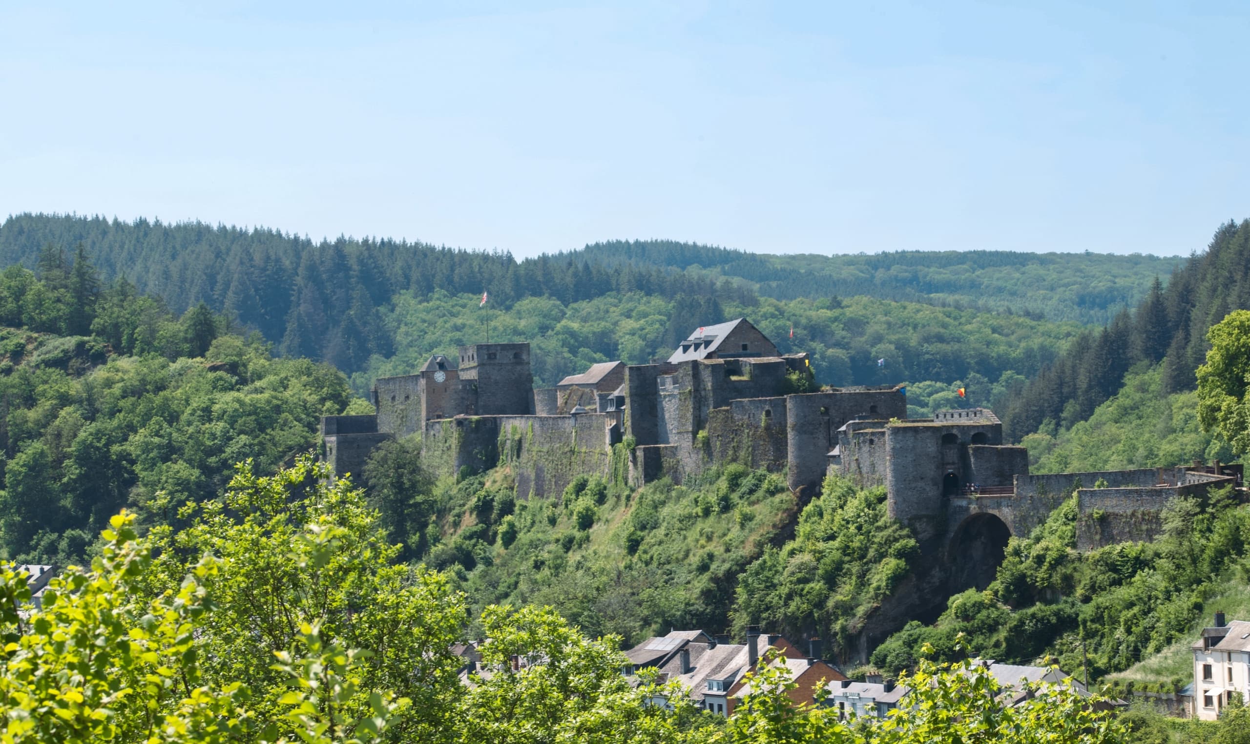 Scenic view of Luxembourg City with historic buildings and architecture along the fortification walls, featuring the old town's characteristic stone buildings and a bridge